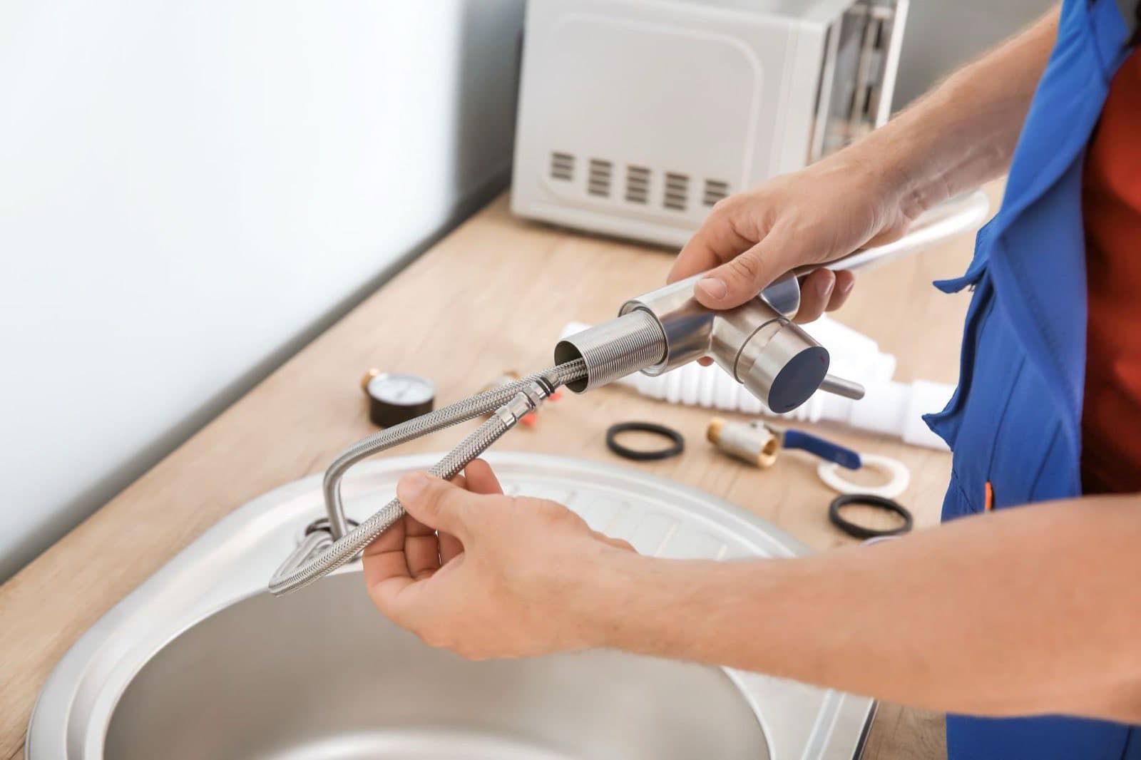 Plumber fitting new tapware to a bathroom basin