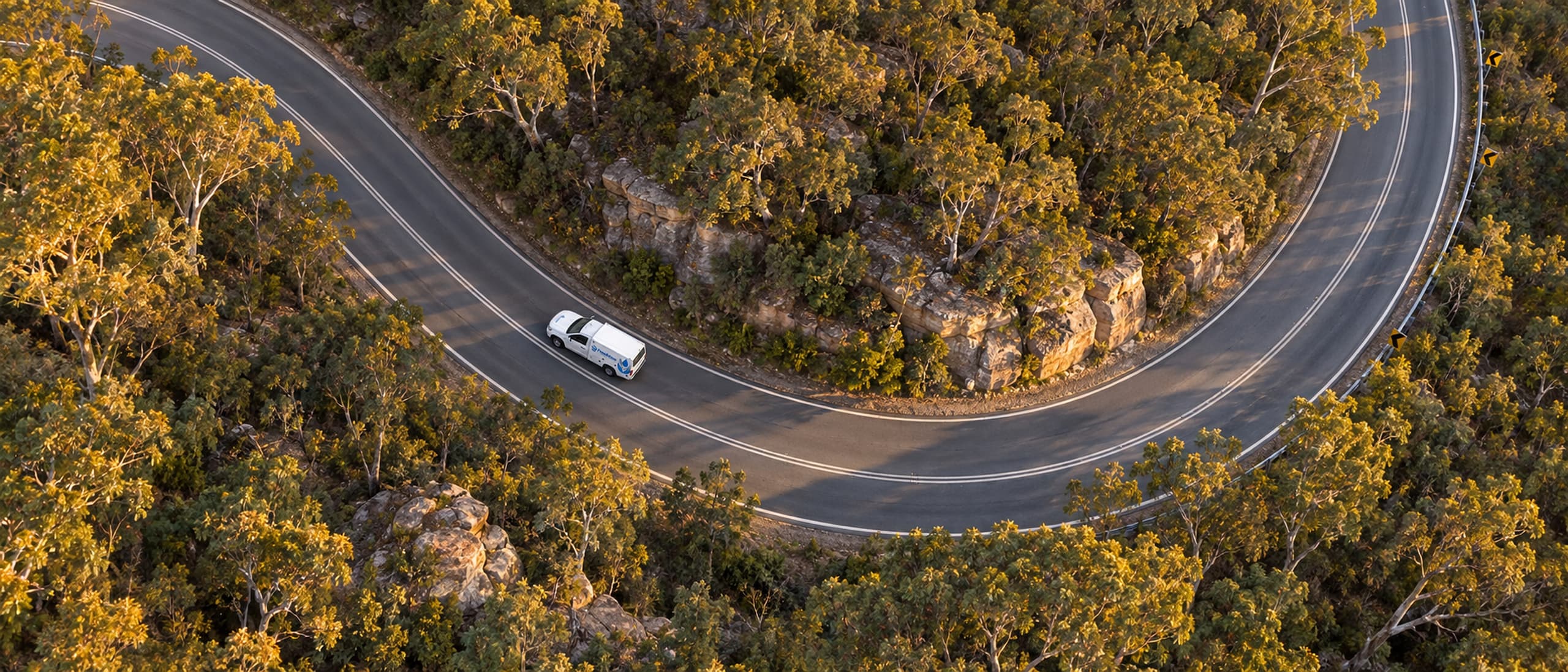 Franklins Plumbing Services ute on a winding road through bushland